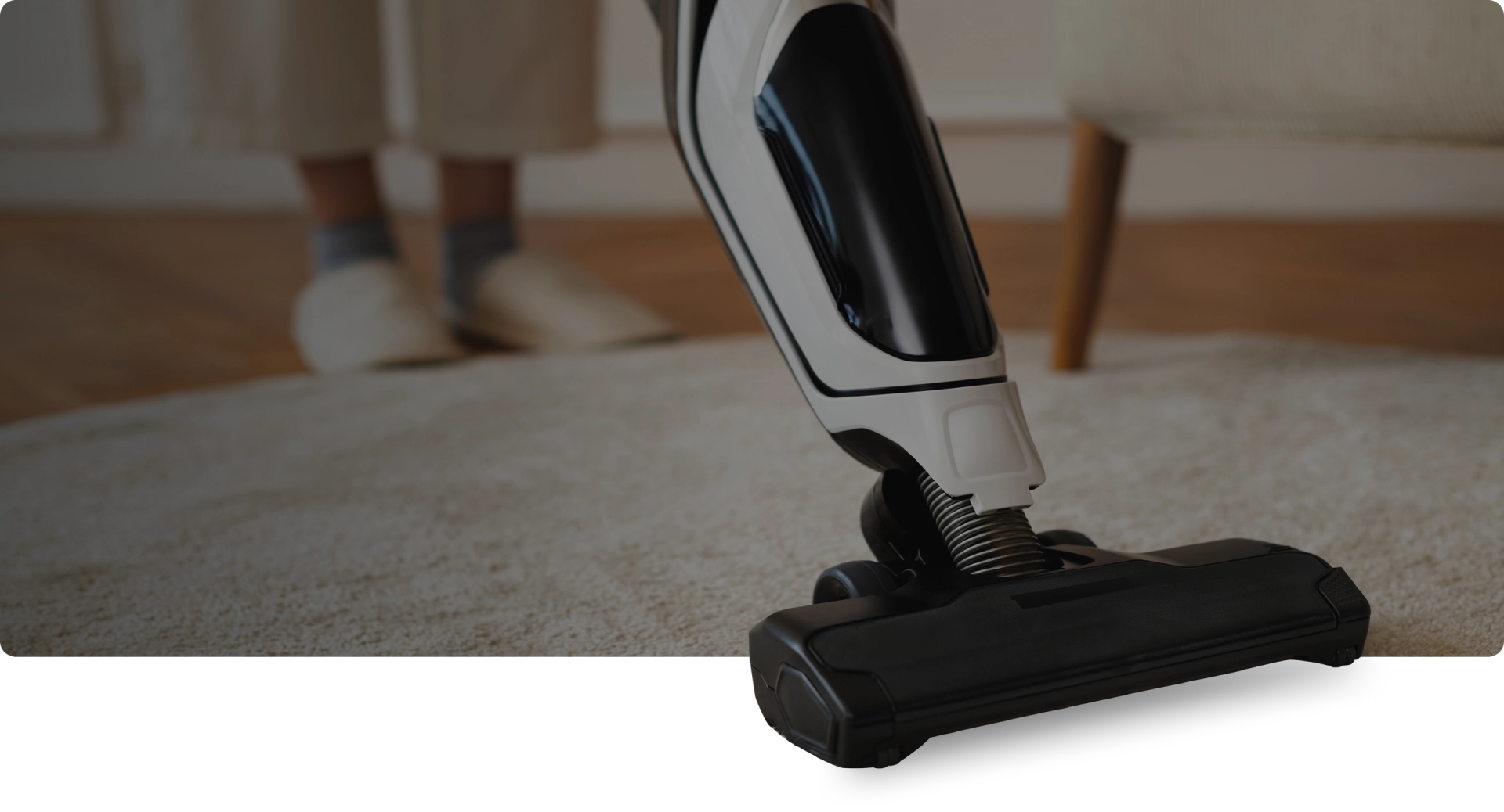 Group 3 (1) Vacuum cleaner on carpet, person in background.